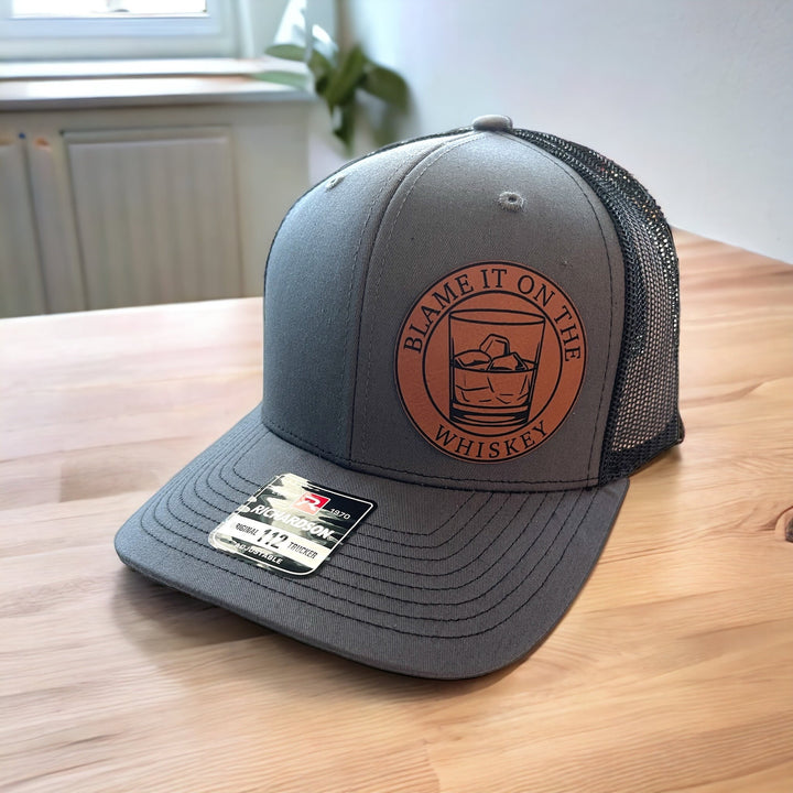 Blame It On The Whiskey leatherette patch trucker hat by BubbleHead Ink