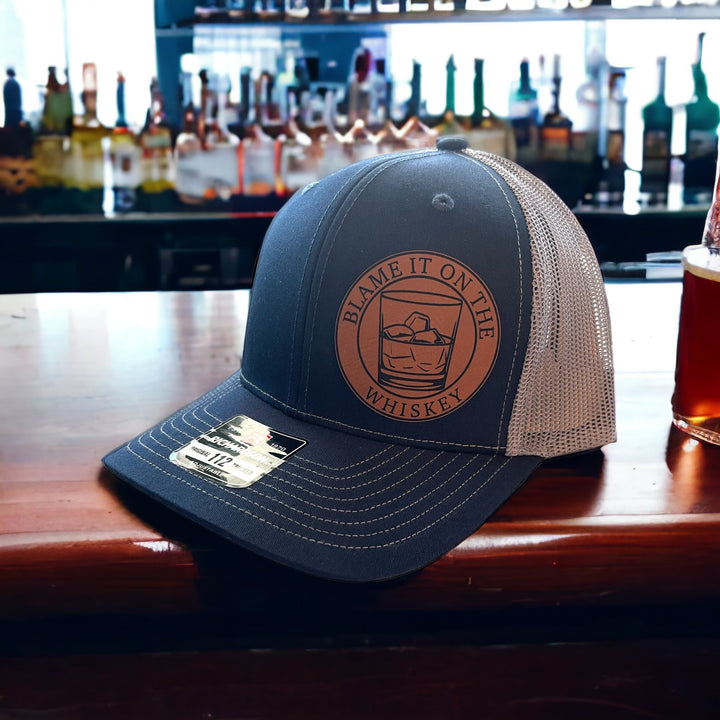 Blame It On The Whiskey leatherette patch trucker hat by BubbleHead Ink