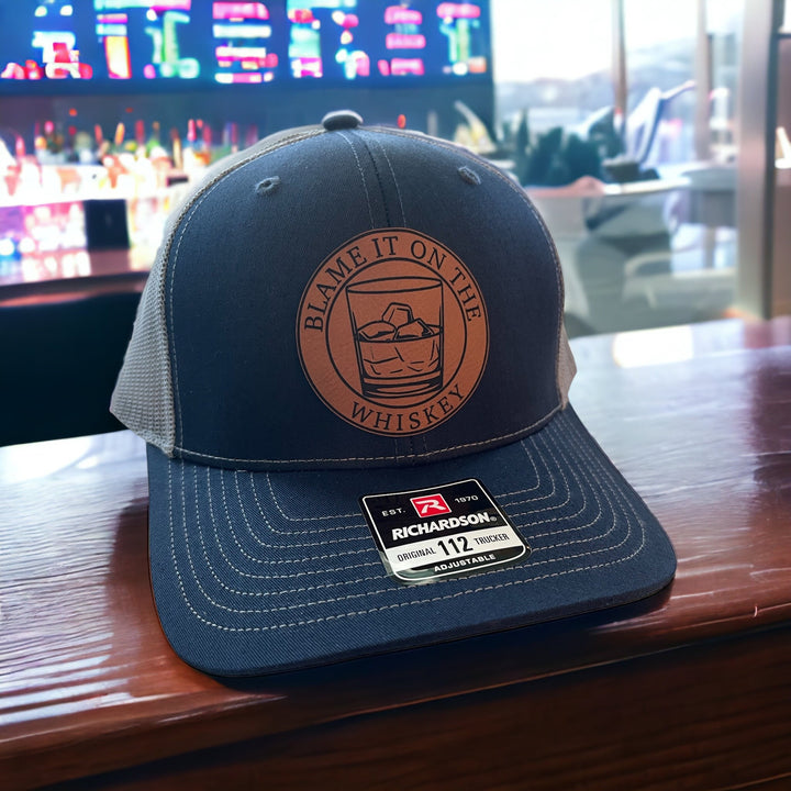 Blame It On The Whiskey leatherette patch trucker hat by BubbleHead Ink