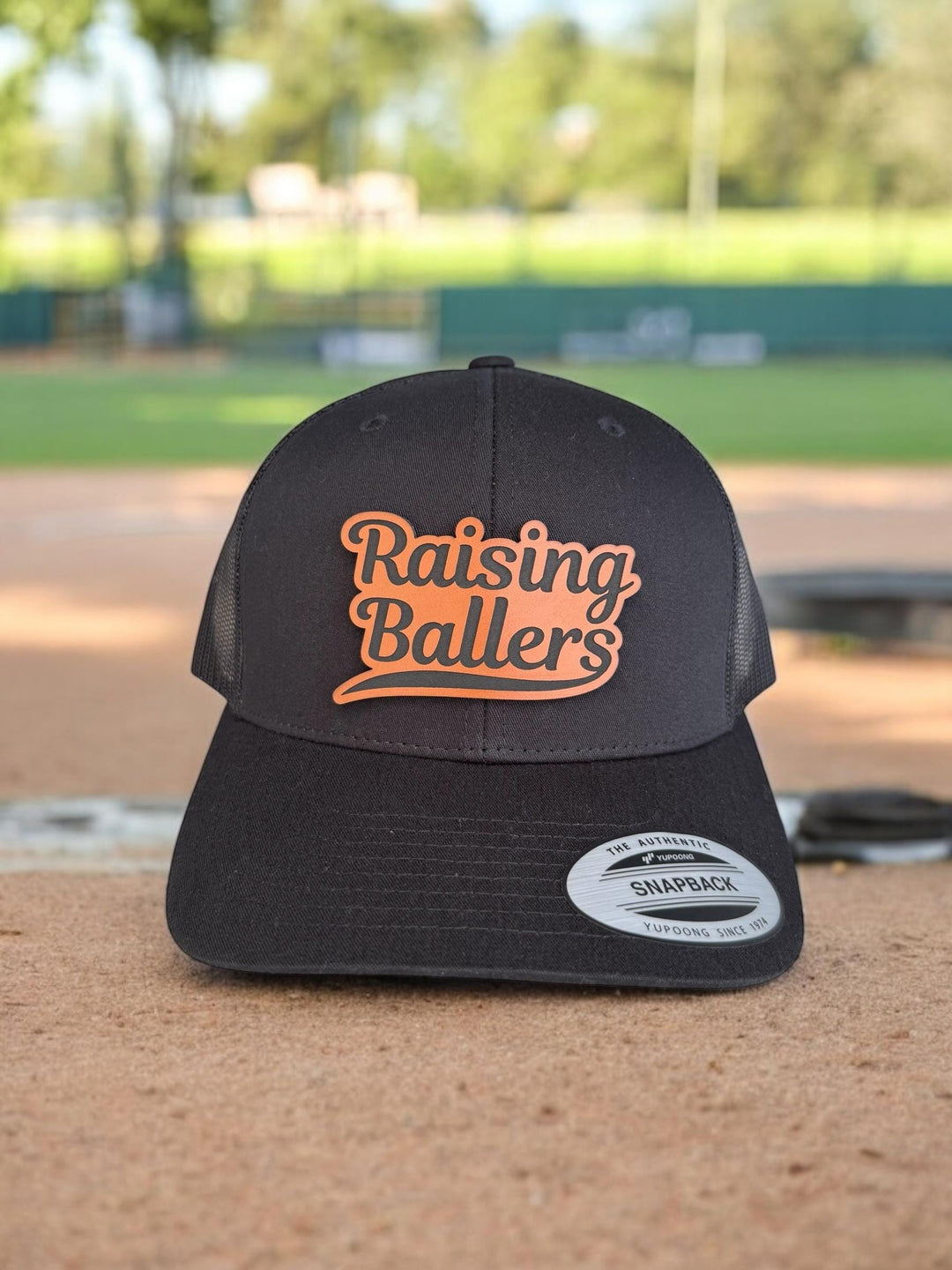 Raising Ballers baseball and football dad trucker hat by BubbleHead Ink