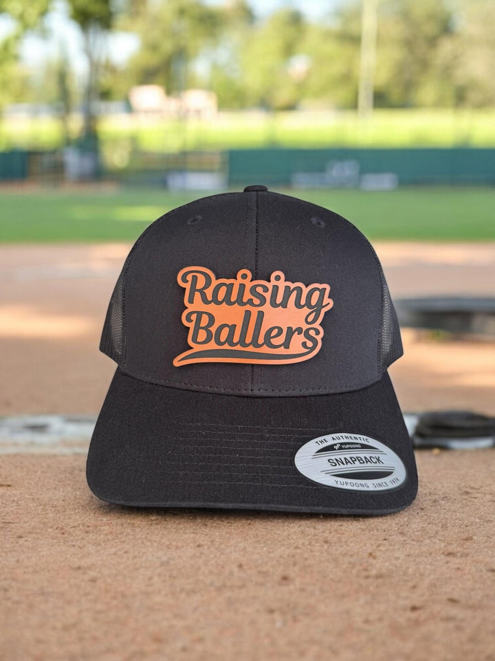 Raising Ballers baseball and football dad trucker hat by BubbleHead Ink