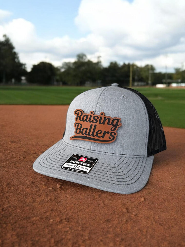 Raising Ballers baseball and football dad trucker hat by BubbleHead Ink