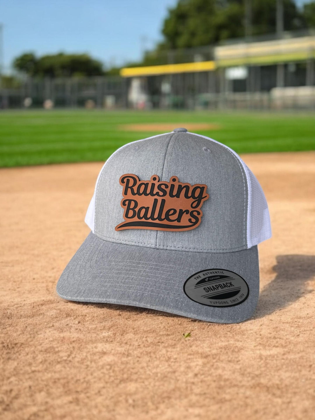Raising Ballers baseball and football dad trucker hat by BubbleHead Ink