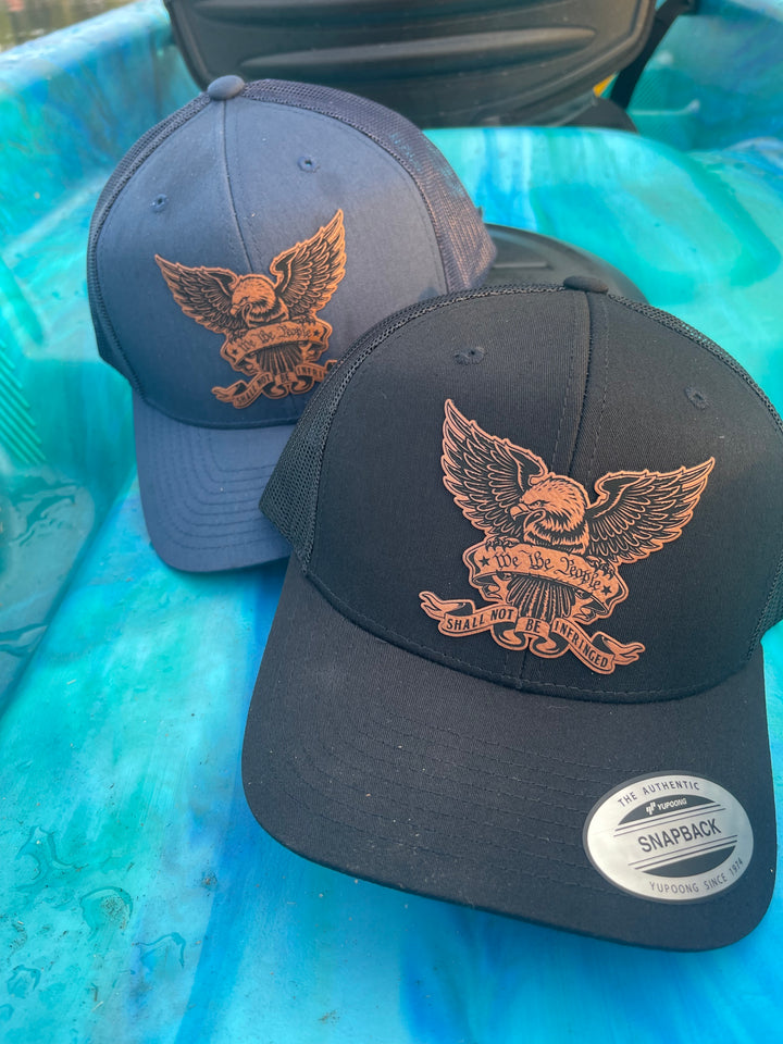 We The People eagle trucker hat in navy and black by BubbleHead Ink