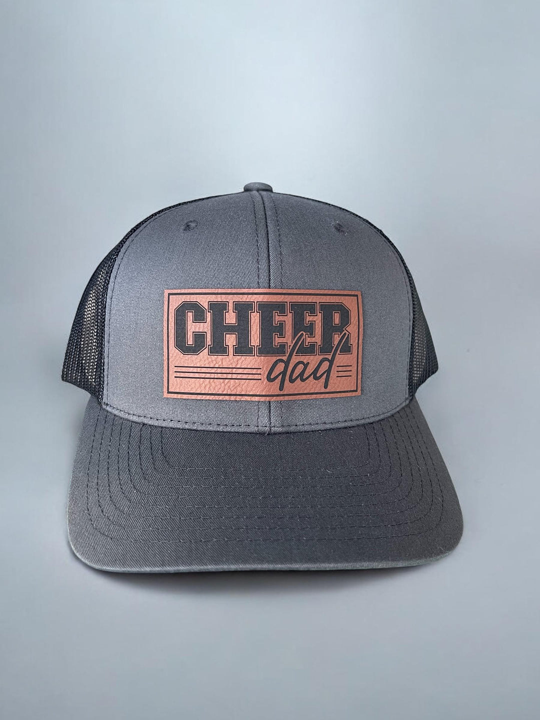 Yupoong 6606 Cheer Dad Trucker Hat with a durable structured charcoal front and adjustable snapback. Ideal for game days and competitions.